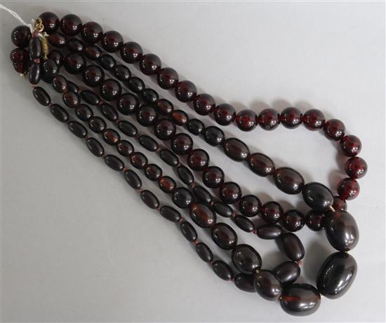 Three single strand assorted simulated cherry amber bead necklaces, largest 48cm.
